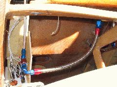 View down onto header showing hose from tank outlet (top right) running to the left to the top of the fuel shutoff valve. Aluminum hardline visible at left running forward to firewall bulkhead connector. IMG_0419.jpg